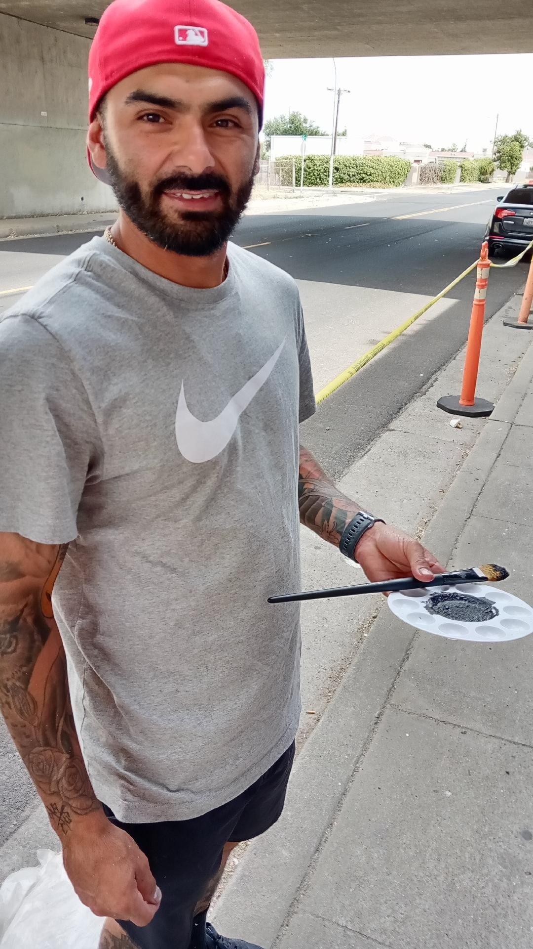  Martin Figueroa with his pallet and brush working on the Canal Street underpass mural in Merced.  Photo:  Steve Newvine 