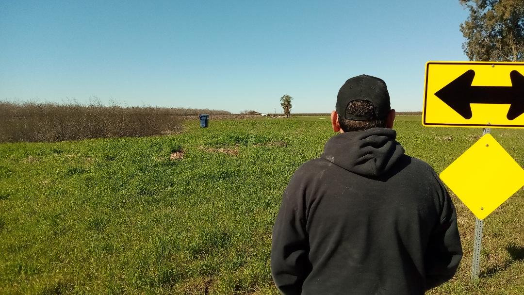 Fernando Nava looks out to a field some 500 feet away from his home. Off in the distance is a trash can that was carried away by flood waters. Photo: Steve Newvine