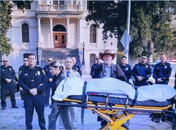 Merced Police Chief Steve Stanfield, CHP captain Tony Domiguez , and County Sheriff Verne Warnke stand behind a gurney with their reminder of how dangerous a traffic collision can be if passengers are not wearing seat belts. Photo: CHP